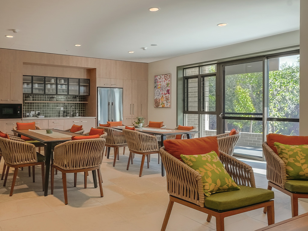 common room at Assisi apartments with kitchenette fridge tables and chairs