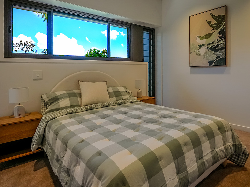 furnished bedroom at Assisi apartments with double bed and bedside tables