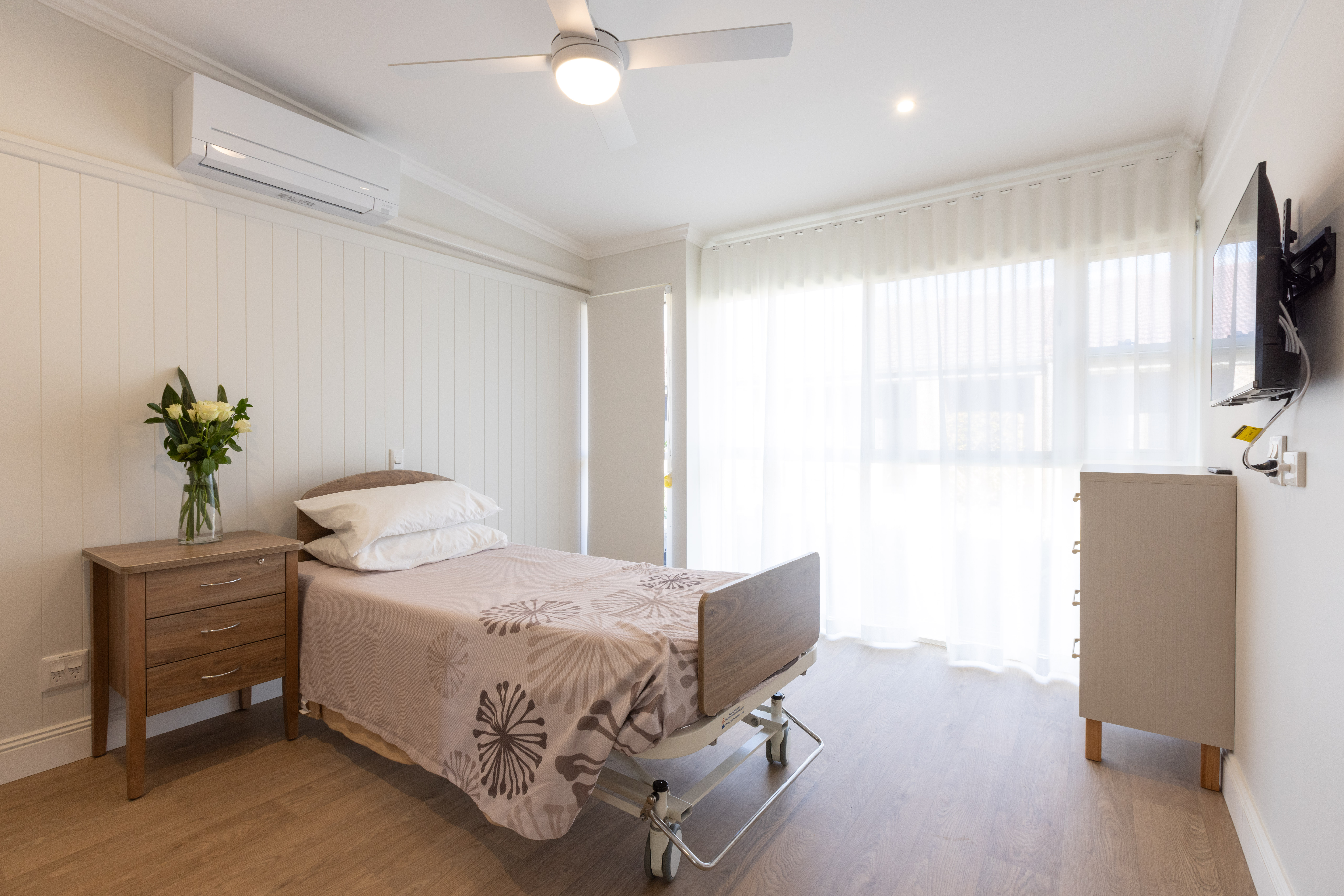 Residential Care room with single bed, TV, window, ceiling fan and airconditioning