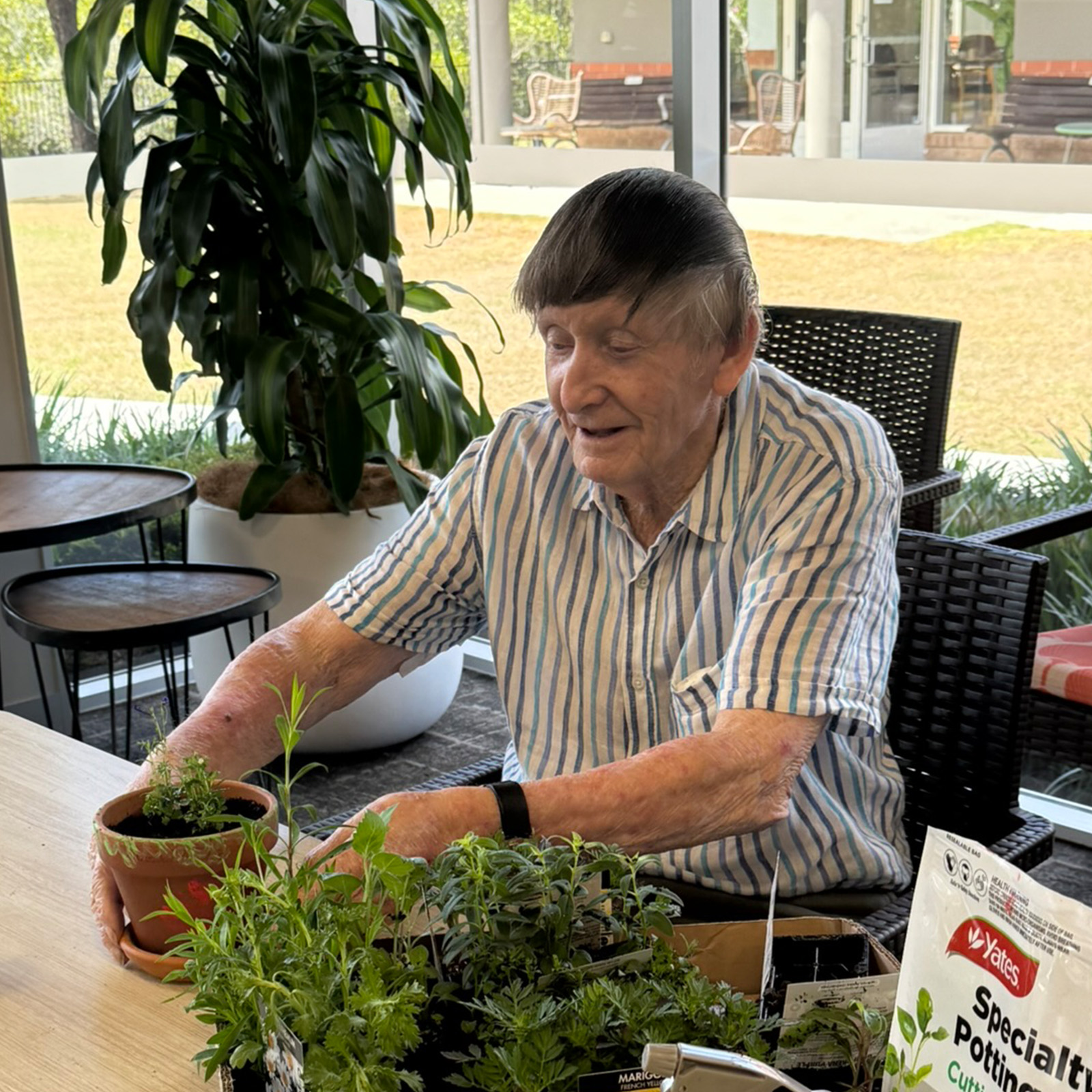 smiling resident gardening with seedlings
