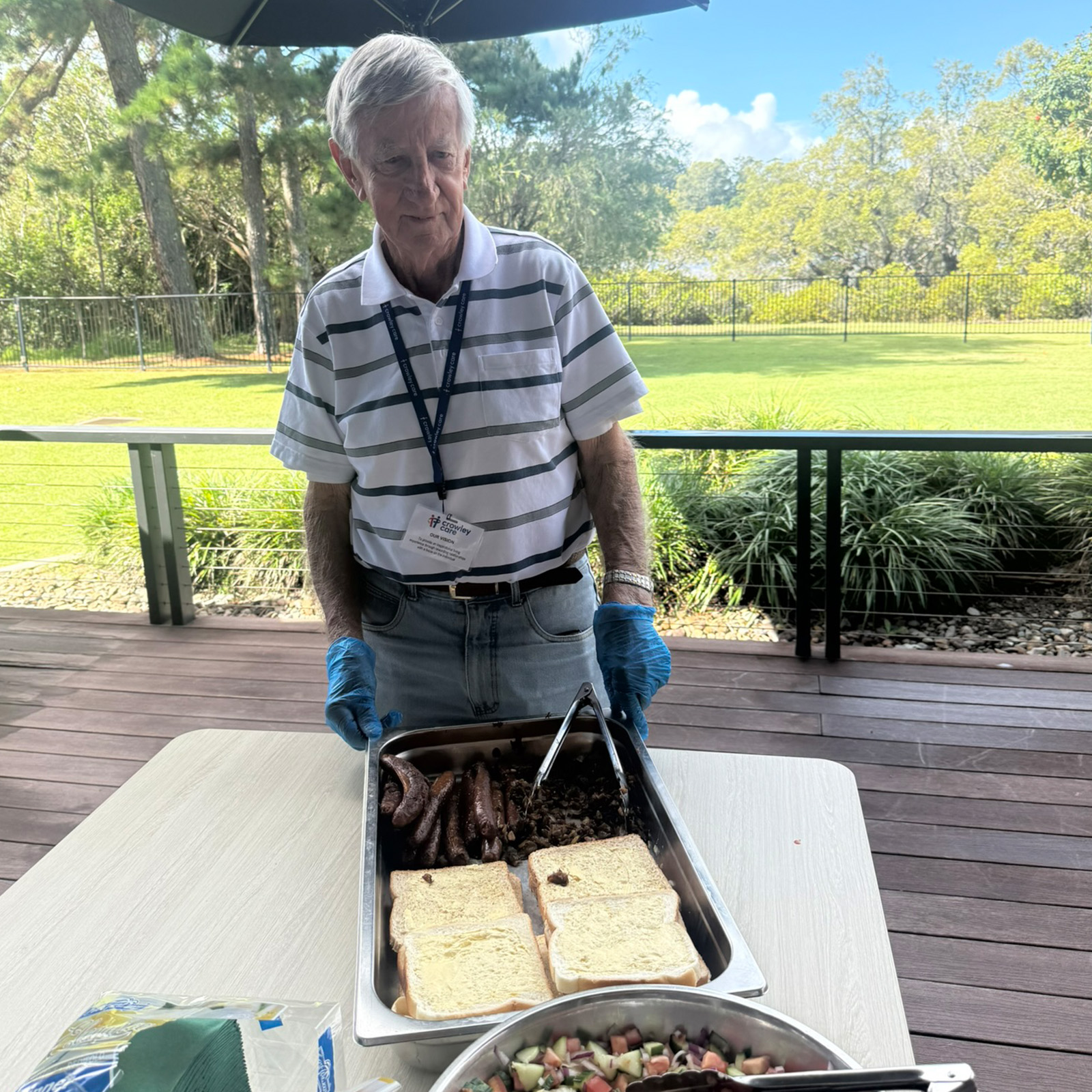 volunteer serving bbq sausage sandwiches on the outdoor balcony of the entertainment room